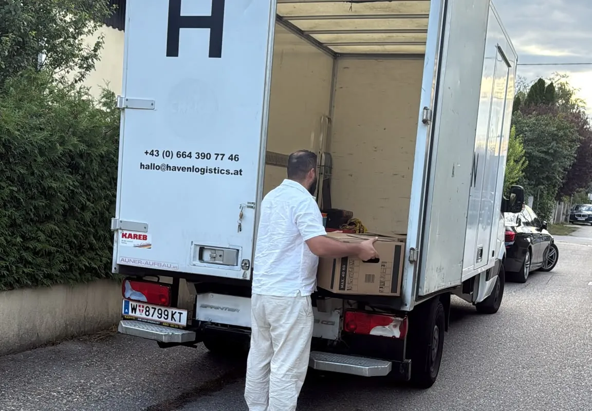 Ein HAVEN-Mitarbeiter lädt Kartons in den Koffer-Aufbau des HAVEN-Fahrzeugs.